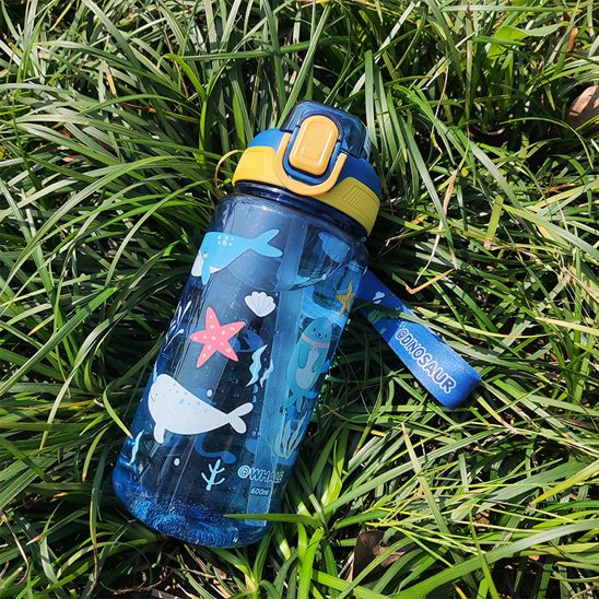 Gourde enfant bleue couchée sur gazon