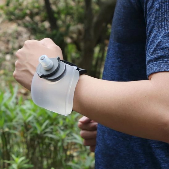 Homme randonnée avec gourde plastique blanche poignet