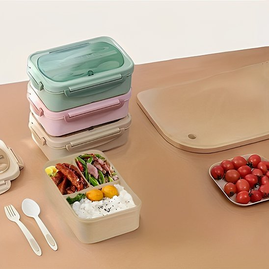 Lunch box beige avec ustensiles sur table