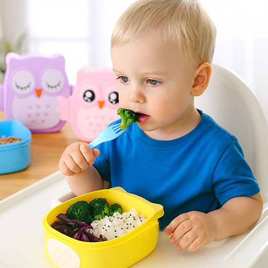 Bambin garçon mange  brocoli dans Lunch box enfant jaune