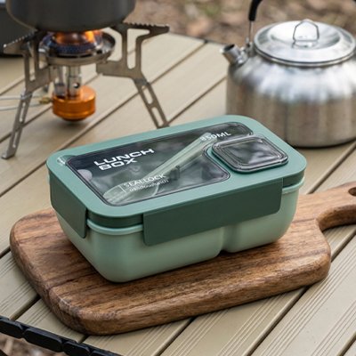 Boite a lunch verte sur table pique-nique camping
