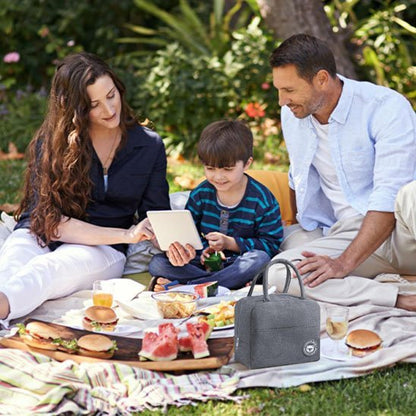 Couple avec garçonnet pique-nique sac isotherme gris sur nappe