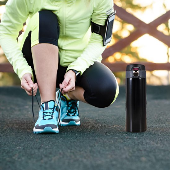 Femme jogging avec isotherme bouteille