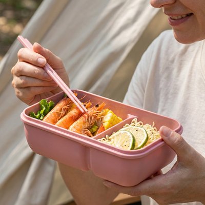 Femme mange avec boite a lunch rose plein air
