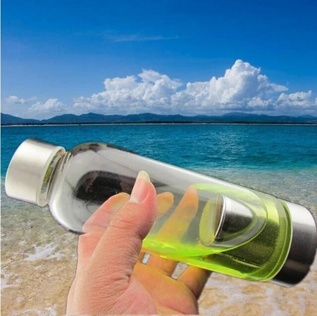 femme plage tient gourde en verre