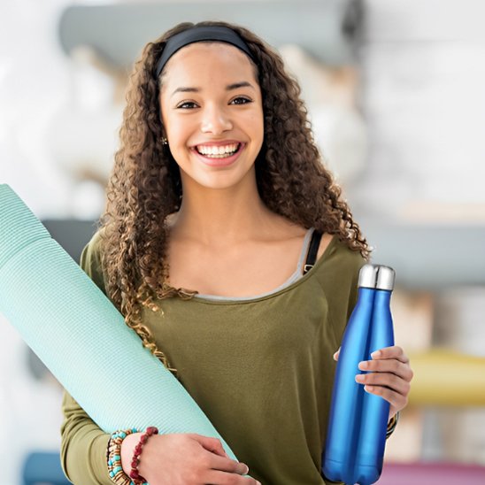 Femme pratiquant yoga avec bouteille isotherme bleue marin