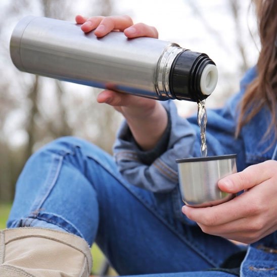Femme vide boisson dans gobelet gourde isotherme 1 litre