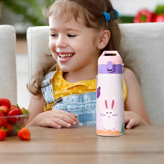 Fillette à table avec gourde enfant rose 