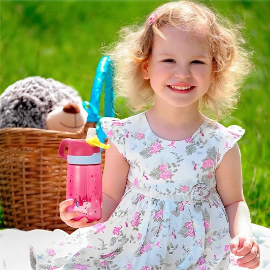 Fillette pique-nique tient dans main gourde enfant rose 