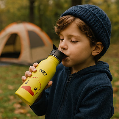garçonnet boit gourde avec paille jaune camping