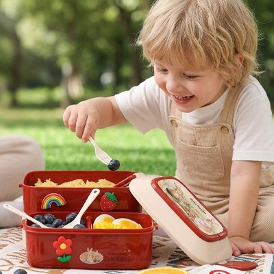 Garçonnet pique fourchette dans lunch box enfant camping