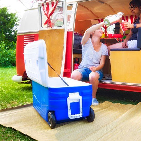 Glaciere ouverte devant campeurs dans camping-car