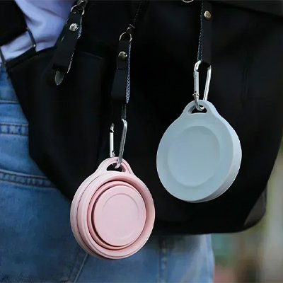 Gobelet pliable rose et un bleu accrochés sac à dos grâce mousqueton intégré