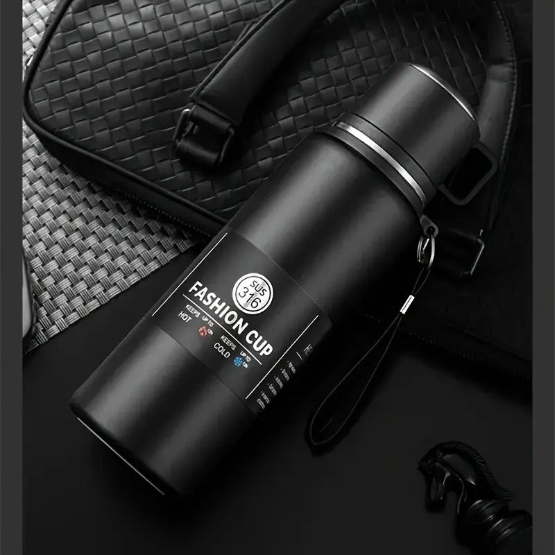 gourde 1 5l noire couchée sur sac à mains