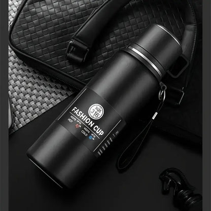 gourde 1 5l noire couchée sur sac à mains