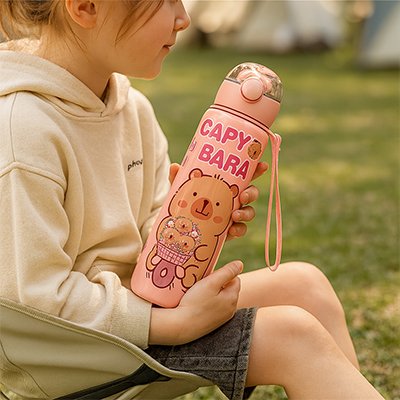 Gourde enfant rose dans mains fillette camping