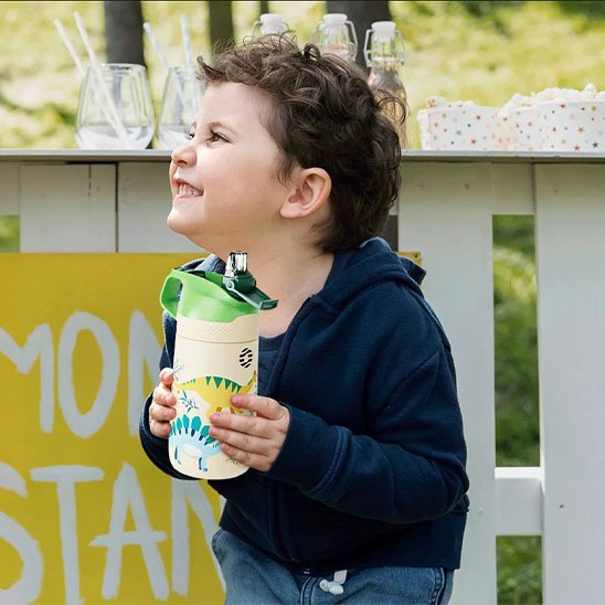 Gourde enfant verte dans mains garçonnet pique-nique