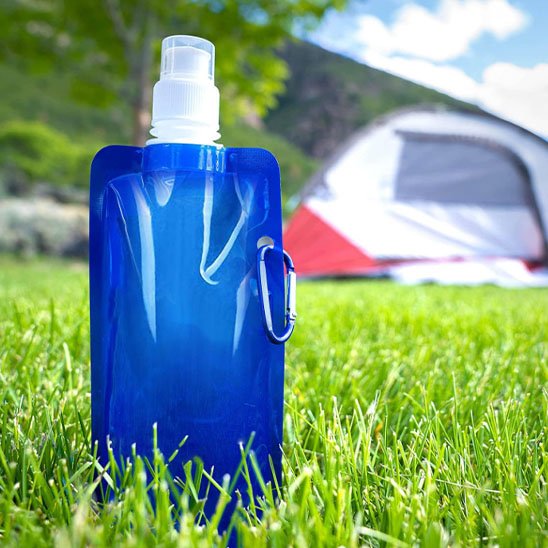 Gourde plastique bleue sur pelouse camping