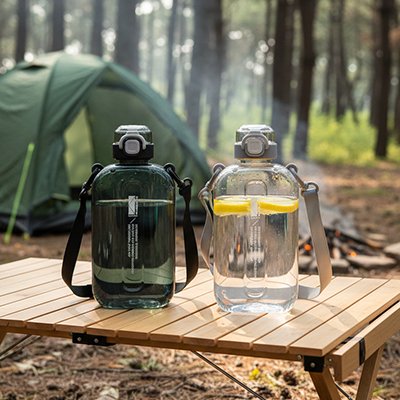 Gourde plastique en vert ou en blanc sur table camping