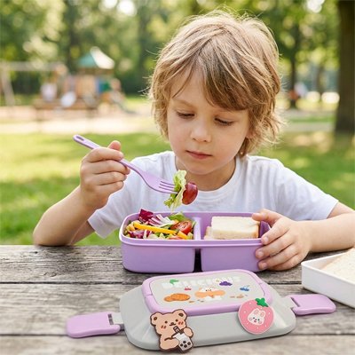 Jeune enfant mange avec lunch box enfant plein air
