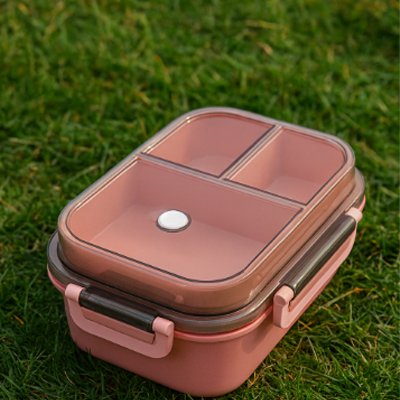 Lunch box rose sur pelouse