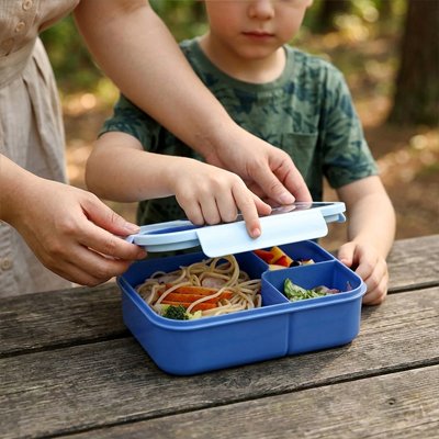 Maman ouvre lunch box enfant de fiston pique-nique