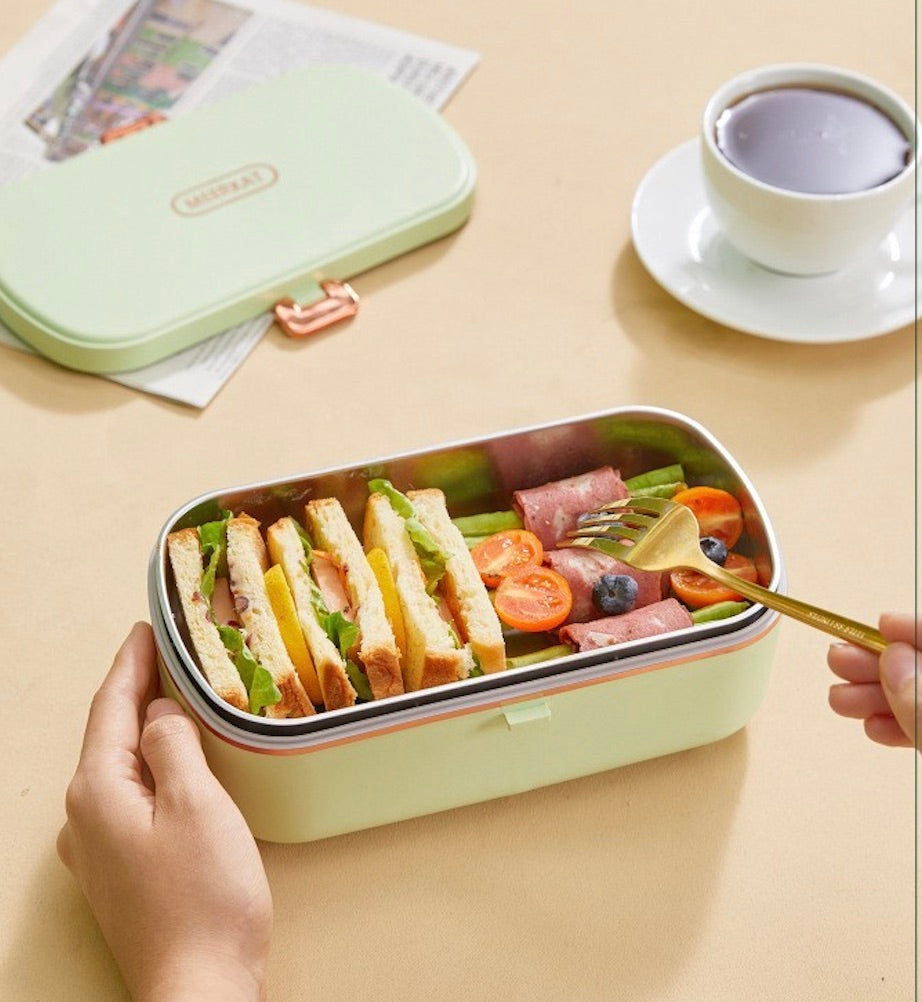 Personne mange dans lunch box chauffante verte pâle