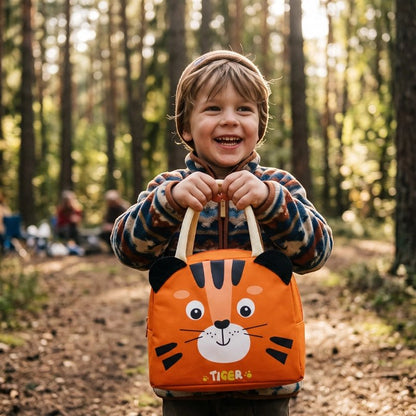 Petit campeur tient fièrement sac isotherme tigre orange