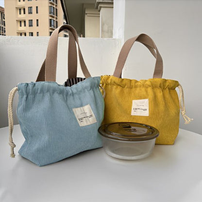 sac repas isotherme bleu ou jaune sur table terrasse